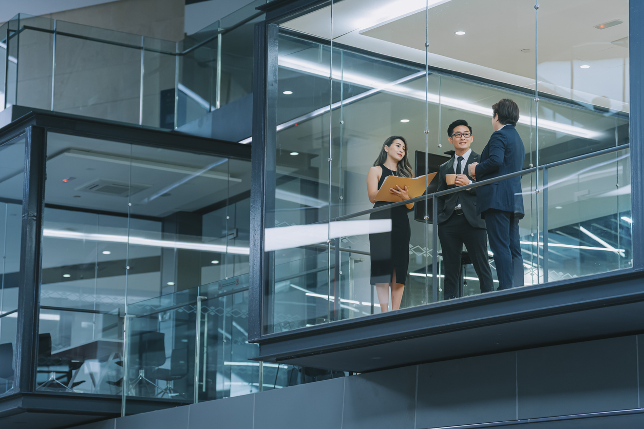 Business professionals collaborating in a modern glass office atrium