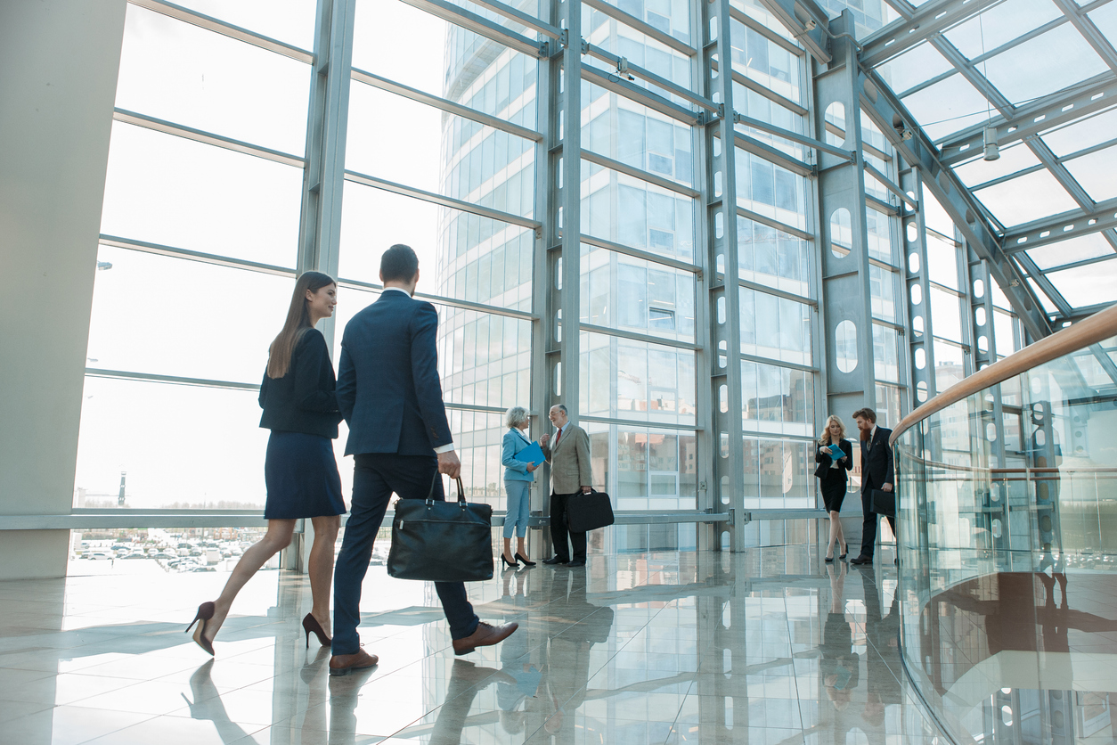 Professionals walking through a modern financial district lobby